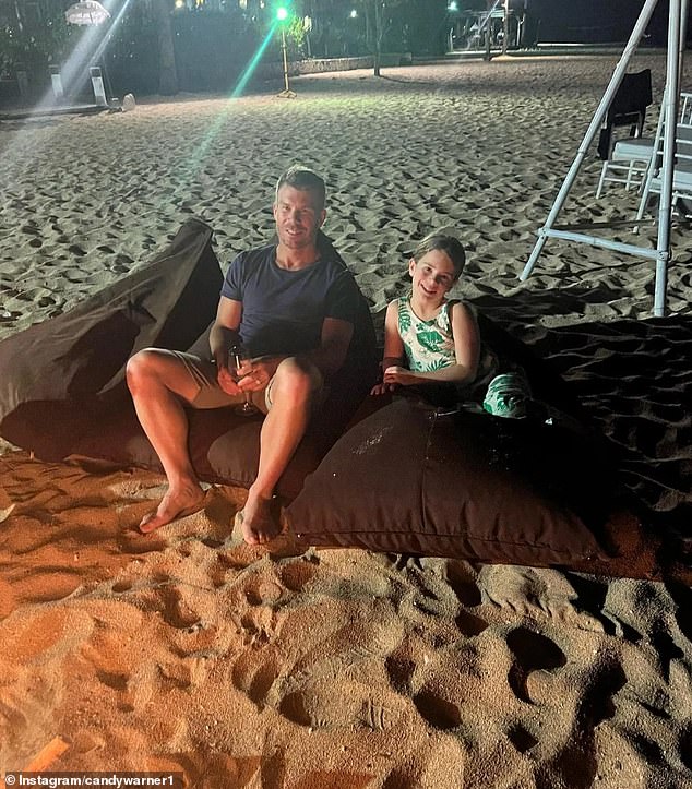 Social media photos show the barefooted couple relaxing on large beach cushions, sipping from Champagne flutes, and roasting marshmallows over a camp fire with their kids