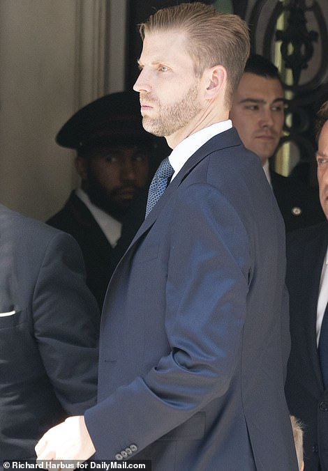 Eric Trump fixes his tie outside the funeral home