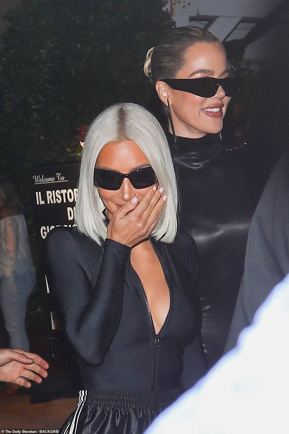 High spirits: Khloe beamed with joy while her sister covered her mouth