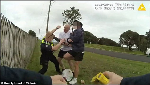 Steven John Cleary and a boy grapple with an officer as his partner rushes in to help