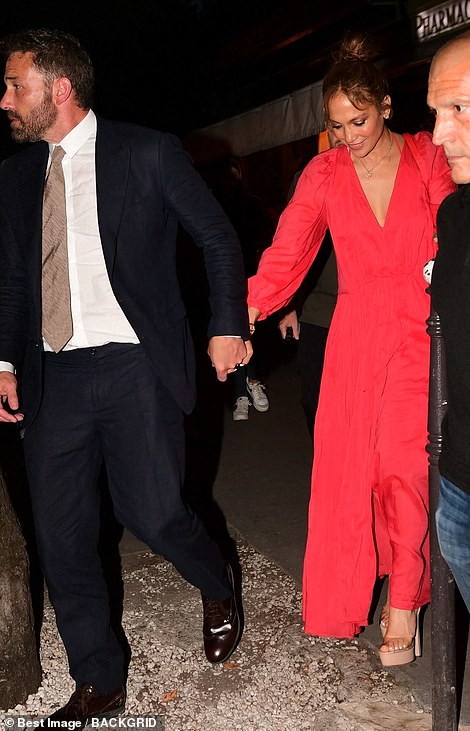 Gorgeous: During the evening outing, Jennifer was the epitome of elegance in a vibrant red long-sleeve maxi dress as she walked hand-in-hand with Ben