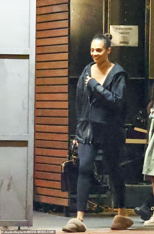 She paired the look with a designer handbag, fluffy brown slippers and her hair pulled back in a tight bun