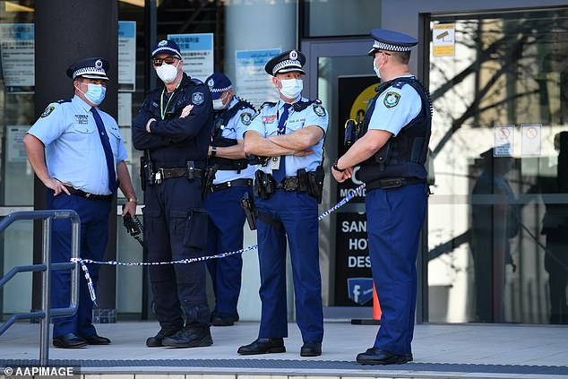 Children aged 10-17 have either been fined by police for failing to comply with a direction under the public health act or not wearing a mask (pictured, masked police officers outside Bankstown Police Station)