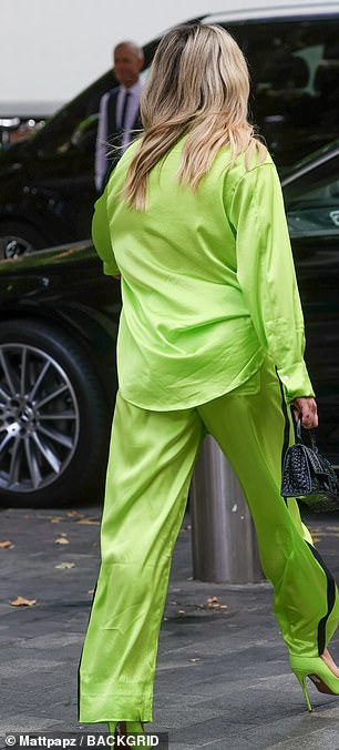 Sporty chic: The broadcaster stylishly tucked her shirt into high-waisted trousers which featured black stripes down the sides