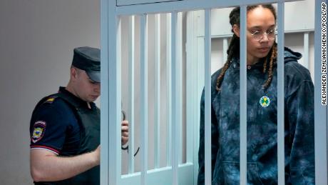 Brittney Griner stands in a cage awaiting a court hearing.