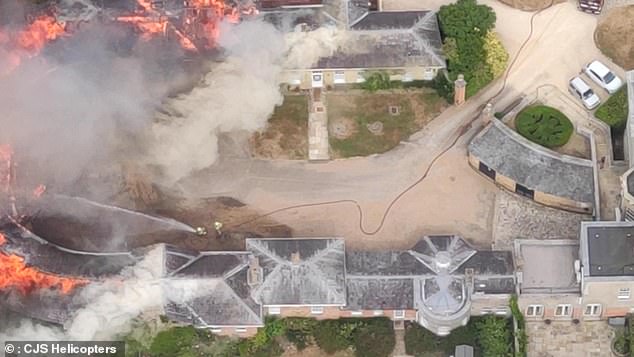 Firefighters are seen tackling the blaze at the Wrotham Park Estate in Hertfordshire this afternoon