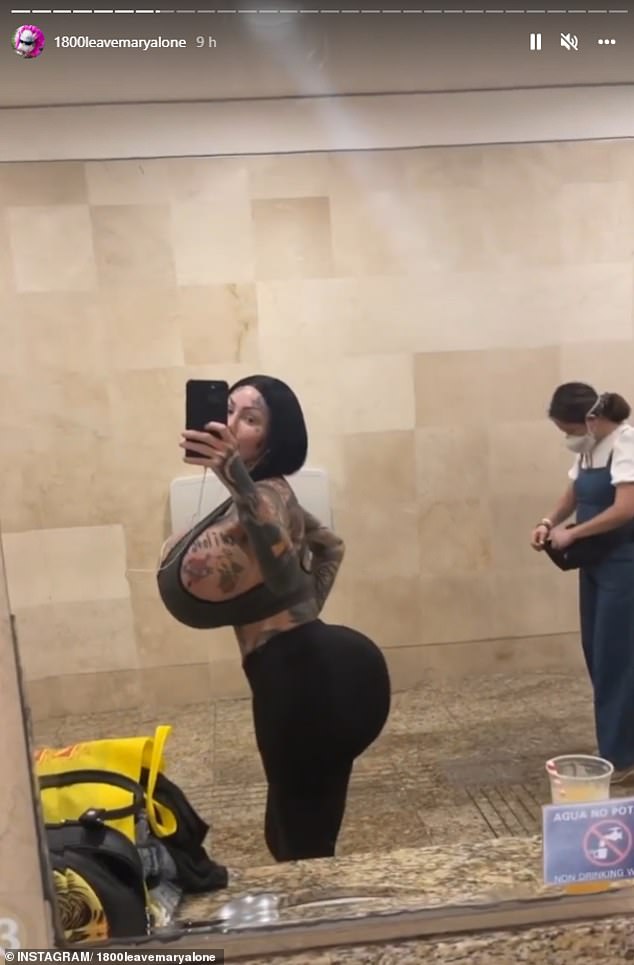 The model filmed herself posing and preening in the bathroom mirror as airport workers and passengers walked in and out