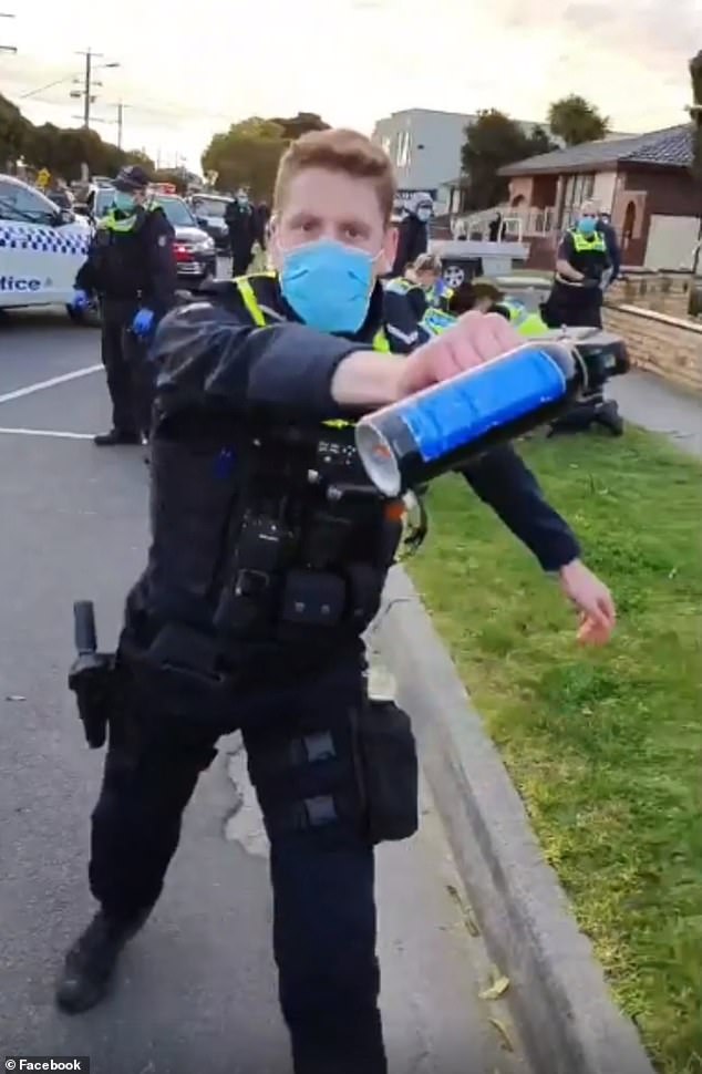 A police officer charges at Dandenong walkers wielding pepper spray in 2020 after his colleagues took down a man who was not wearing a mask