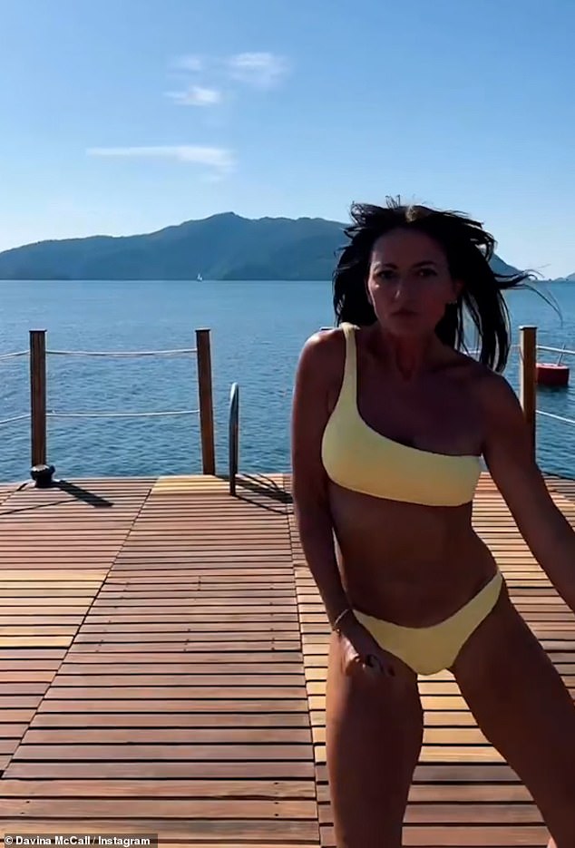 Fun times: Davina oozed confidence as she showed off her bronzed figure while continually strutting, shimmying and skipping in and out of shot in fun poses