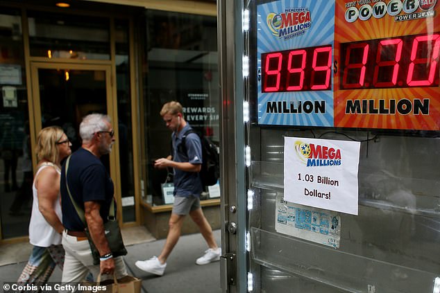 After 29 consecutive drawings, the Mega Millions prize soared to the point where vendor signs had trouble displaying the full amount. Pictured: a store in Manhattan put up a paper note by its lottery display as the electronic sign could not exceed $999 million