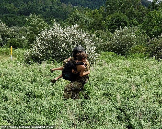 A National Guardsman rescues an individual during the flooding that has killed 26 in Kentucky over the last week