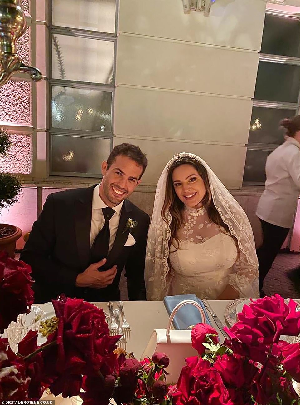 Brook looked stunning in a traditional ivory white gown with sheer lace detail alongside model Parisi in a black three-piece suit