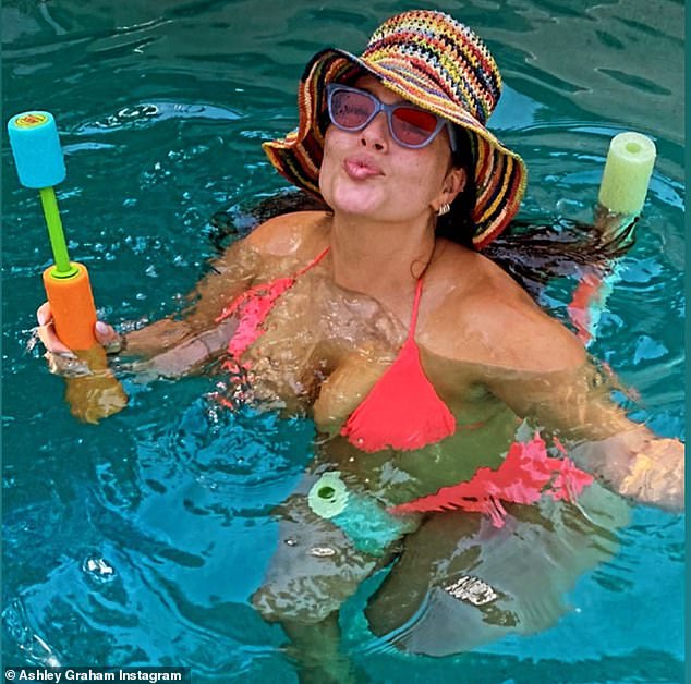 Ashley Graham slips into hot pink bikini for pool party fun