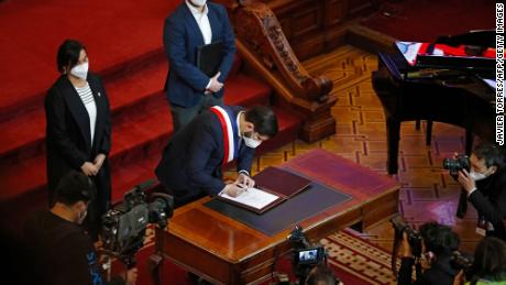 President Boric signing the proposal.