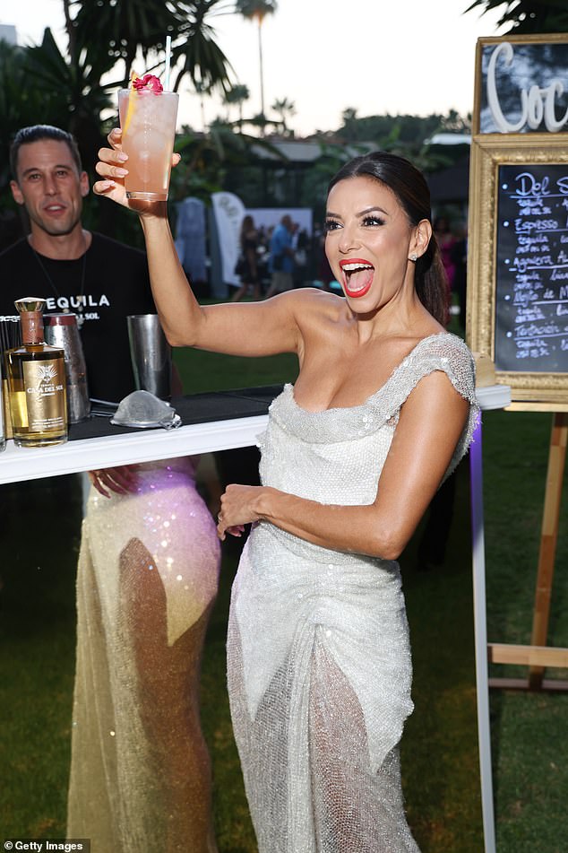 Eva Longoria enjoys a cocktail and dazzles in a silver gown at the Global Gift Gala dinner