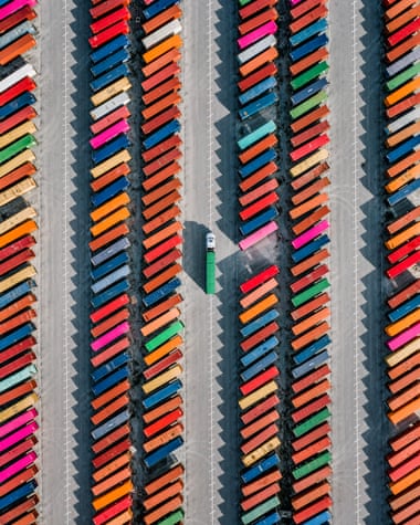 Aerial shot of a truck picking up a cargo crate in a container yard