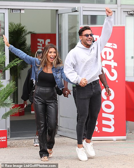 Casual: Leaving the airport hand-in-hand with beau Davide, a beaming Ekin-Su donned a cropped black vest and leather harem trousers