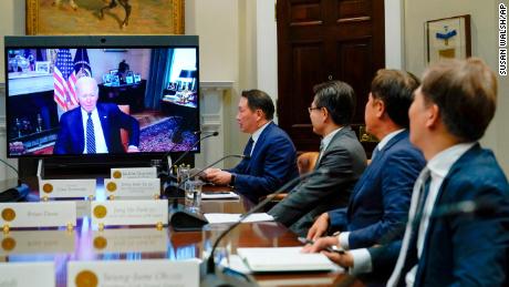 President Joe Biden appears on screen as he listens to SK Group Chairman Chey Tae-won, fourth from right, speak during a virtual meeting in the Roosevelt Room of the White House in Washington, Tuesday, July 26, 2022. The meeting comes as the Biden administration is seeking the cooperation of Asian allies such as South Korea to reinforce supply chains for critical components such as semiconductors. (AP Photo/Susan Walsh)