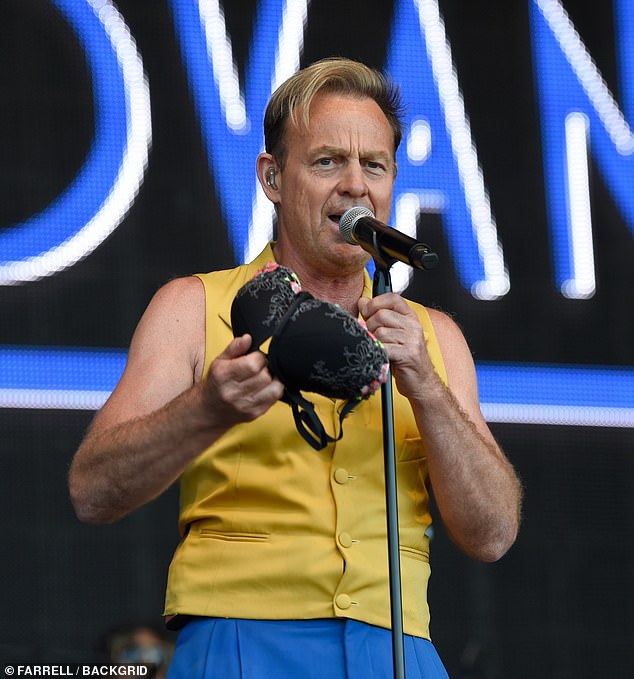 Confused? Pop star Jason was caught off guard before picking the black bra with floral detail up off the stage while looking out across the crowd during his set