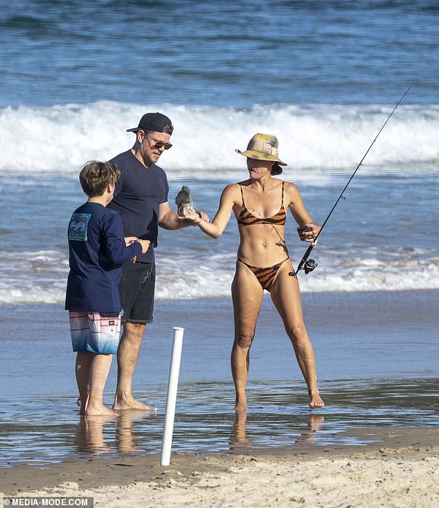 Matt also looked buff as ever in a tight blue T-shirt and board shorts. Pictured with a mystery female pal (right) and unknown child (left)