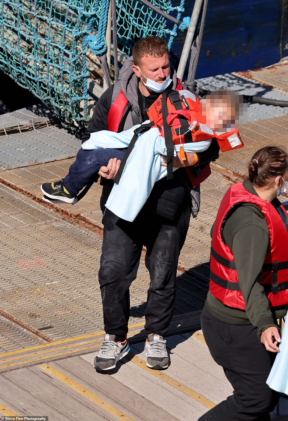 The group included a number of young children, with a soldier seen carrying a small baby along the gangway to be processed by UK officials