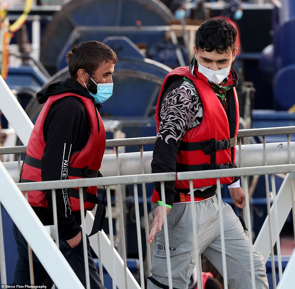 The first group of at least 80 people were brought into Dover, Kent, on-board Border Force ship Typhoon shortly before 7am. Two men could be seen supporting each other by holding hands as they walked along the gangway