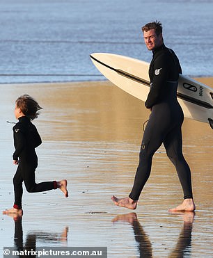 Proud: Chris proudly watched over one of his young ones as they ran straight for the water