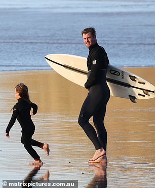 Proud: Chris proudly watched over one of his young ones as they ran straight for the water