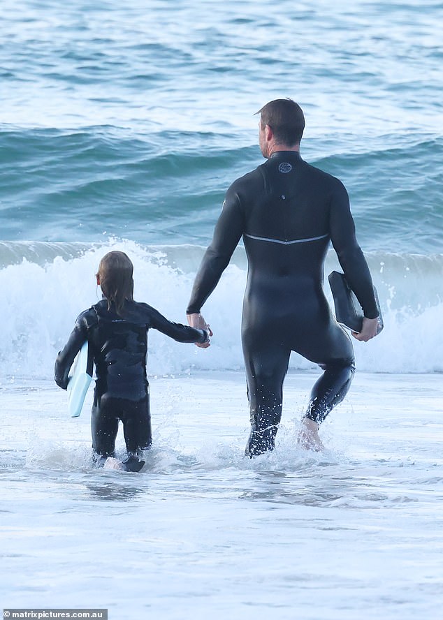 Fun in the sea: Later they swapped their surfboards out for kickboards for some more in-the-water fun