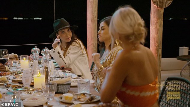 Sara, Nina and Caroline S. engaged in conversation at the nighttime dinner gathering