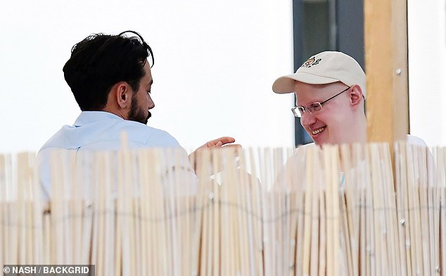 Good spirits: Also wearing a white cap, the Great British Bake Off host completed his look with a pair of blue trainers