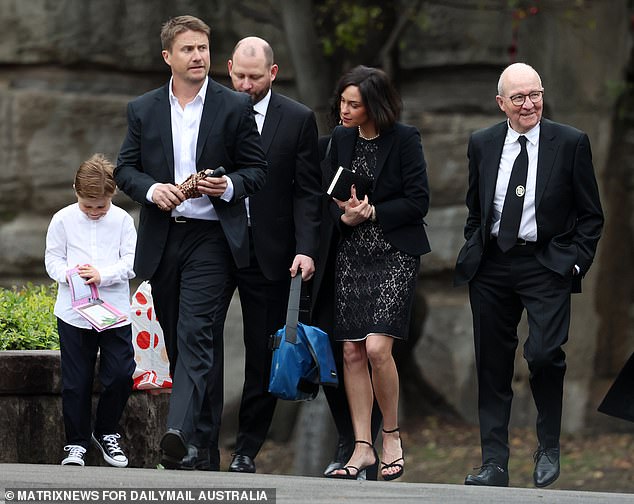 Di's son son Alex (second adult from left) and daughter Victoria (above) came to the Anglican service to celebrate a life well lived with their 80-year-old father (far right)