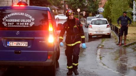 A firefighter walks by a hearse on the site of the attack in Cetinje, 36 kilometers (22 miles) west of Podgorica, Montenegro, Friday, Aug. 12, 2022. 