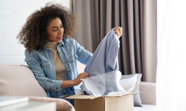 A customer unpacks a fashion delivery box at home.