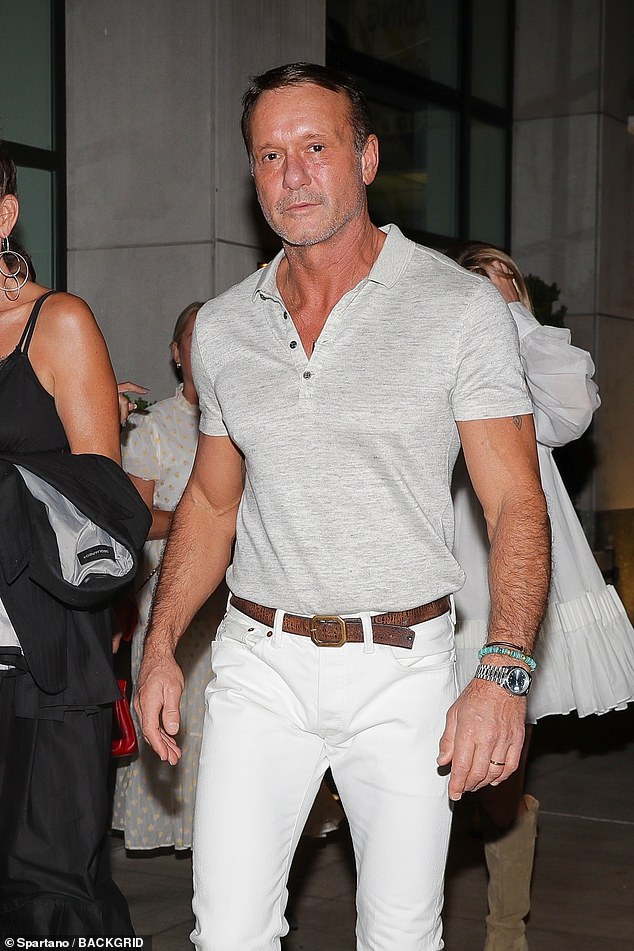 Cool dude: The 55-year-old country icon chose white fitted jeans and a tight pale gray polo shirt for the dinner celebration