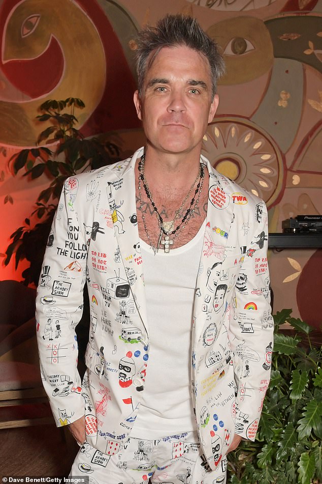 Smarty: Robbie layered the striking ensemble, with matching blazer and shorts, over a low cut white vest, which flashed a glimpse of his tattoos and chest hair