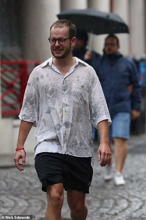 People walk through London in the rain yesterday