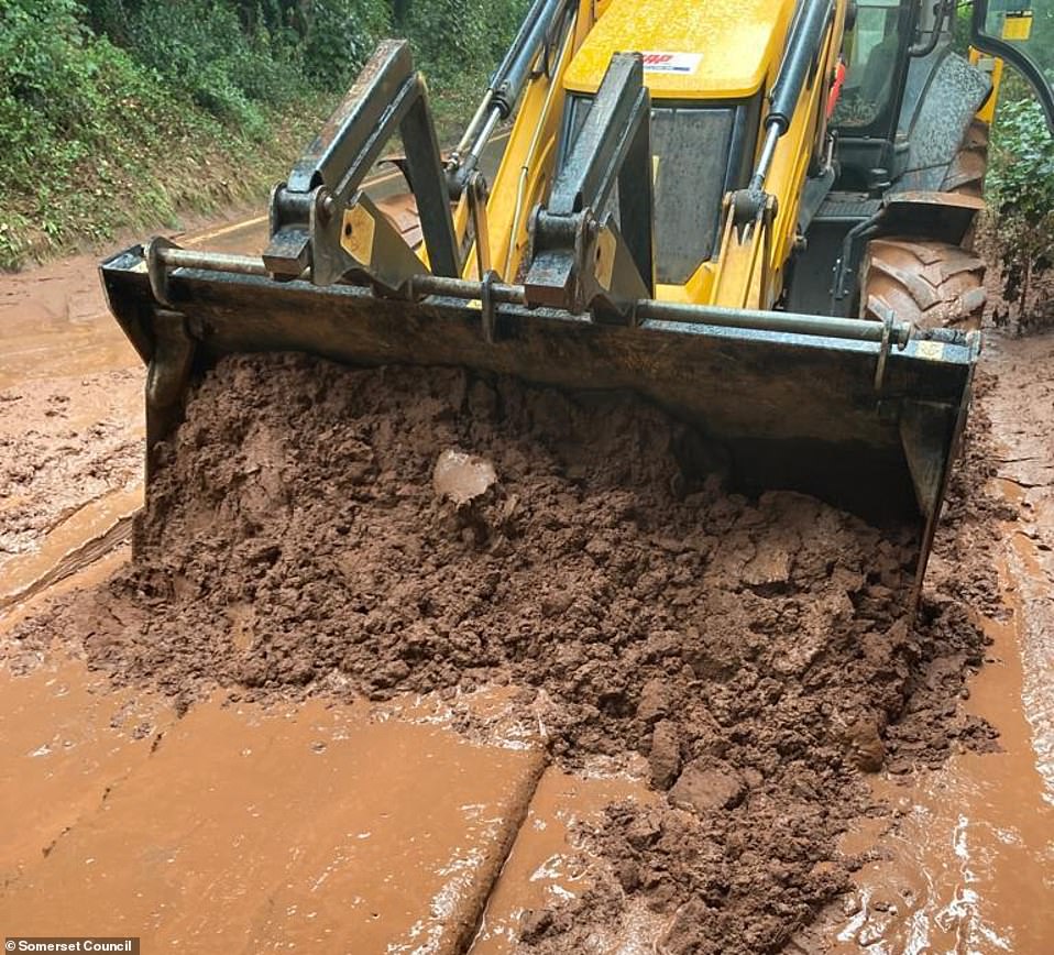 A tractor works to clear A358 in Somerset yesterday after it was closed at Combe Florey following the mudslide last night