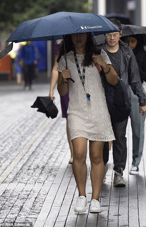 A woman with an umbrella in London yesterday