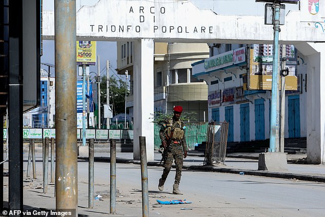 A security officer patrols nearby the the site of explosions in Mogadishu