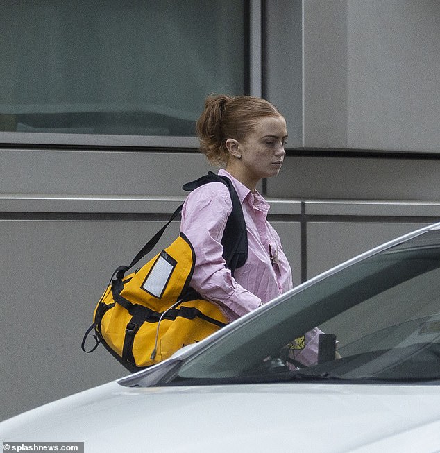 Beauty: She carried a large yellow North Face bag, while going makeup free and scraping her auburn locks back into a claw clip