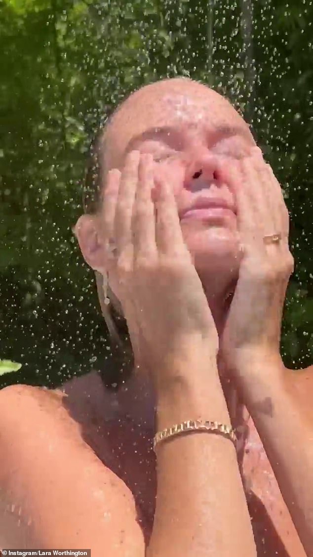 The model, 35, stood surrounded by lush greenery beneath a rainfall shower, soaking in sun and water