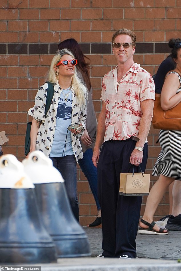 Chic: Following their outing in the city on Thursday, he looked trendy in a cream shirt with red palm tree prints, which he combined with a pair of oversized navy suit trousers