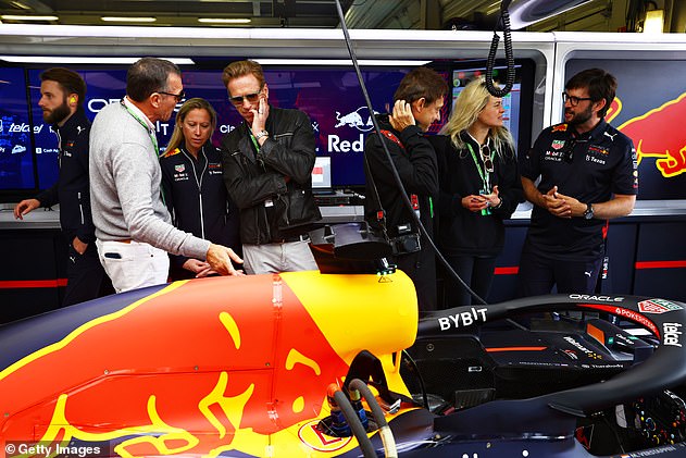 Day out: Photos from Lewis's tour of the Red Bull Racing garage in July show Mosshart standing close by