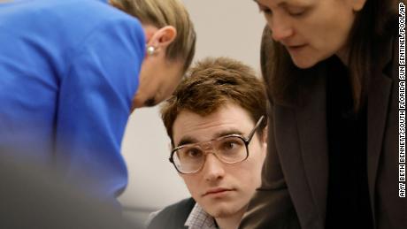 Nikolas Cruz is shown at the defense table as attorney Melisa McNeill, left, and sentence mitigation specialist Kate O&#39;Shea, right, speak during the penalty phase of his trial on Monday, Aug. 22. 