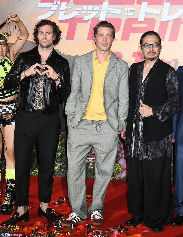 Rocker style: Arron put on an edgy display in an animal print shirt and leather jacket teamed with cropped black trousers and gold-buckle loafers