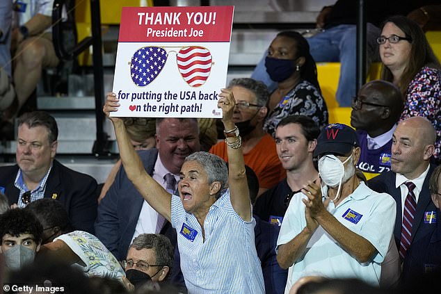 A woman holds up a sign thanking President Joe Biden ahead of the president's appearance Thursday night in Rockville, Maryland