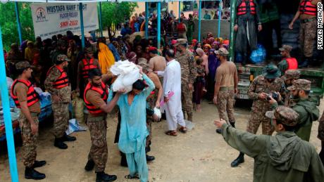 Army troops distribute food and supplies to displaced people at a relief camp in Jamshoro district, in southern Pakistan, on August 24.