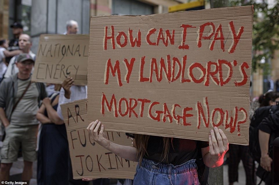 Ten officers were present on the other side of the street as well as security guards, with police vans lining the road outside the building. One woman's sign read: 'How can I pay my landlord's mortgage now?'