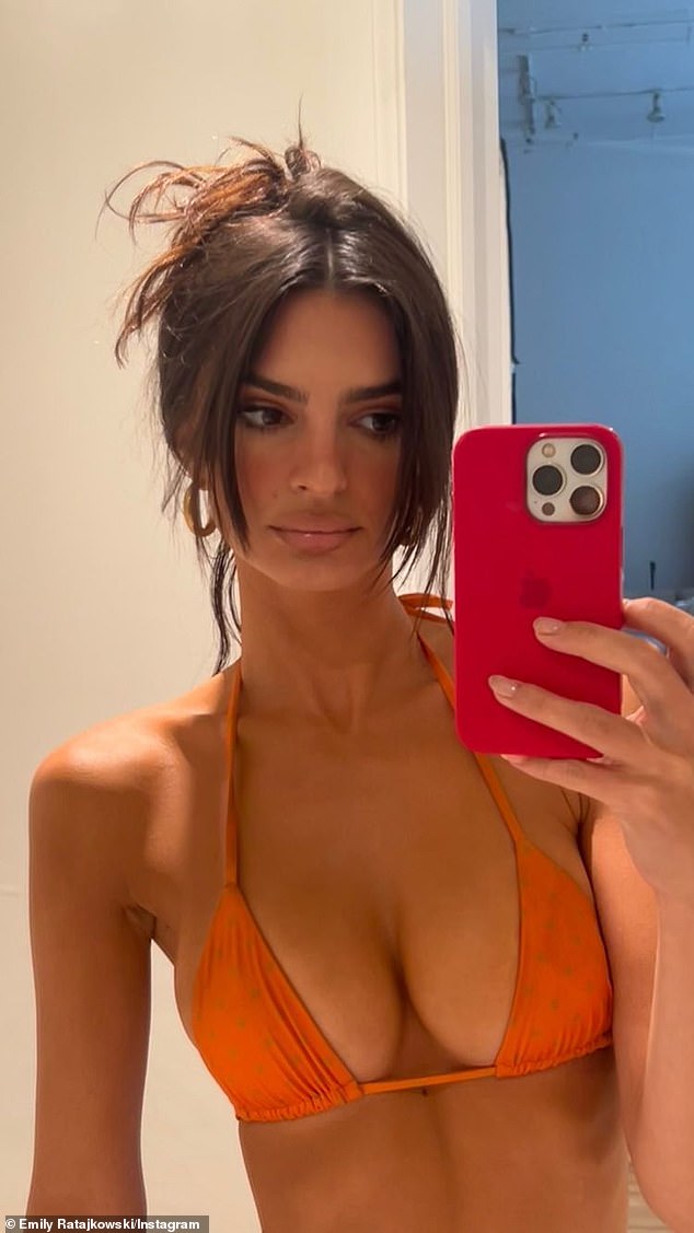 Sultry snap: Ratajkowski showed off a bit more skin in a photo that was shared to her Instagram Story on Friday. Posing in front of a mirror, the model posed in a patterned orange bikini top that showcased her ample chest